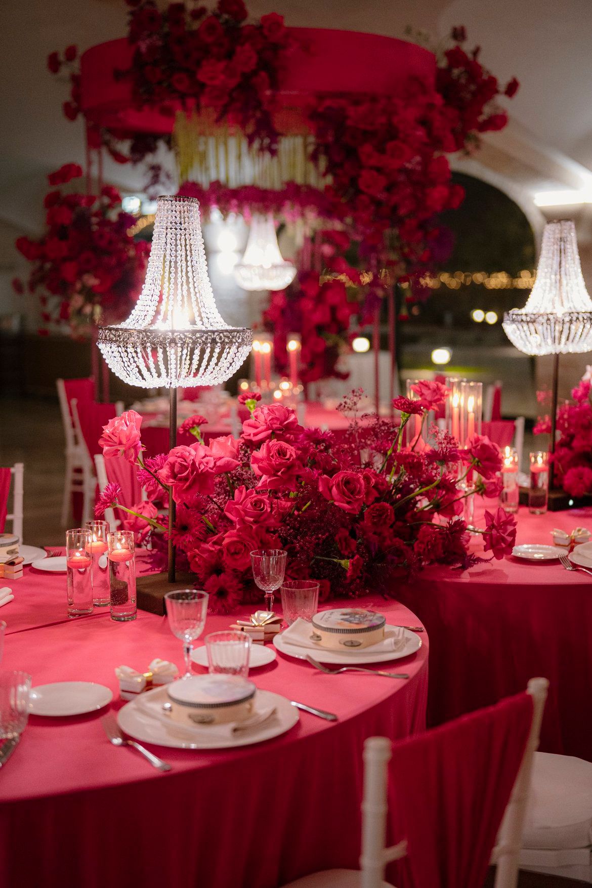 Dettaglio tavolo LIPPOLIS con centrotavola fucsia intenso e lampadario di cristallo Empire